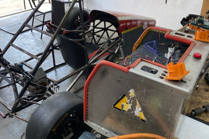The university electric racing car in the workshop with its battery enclosure opened.